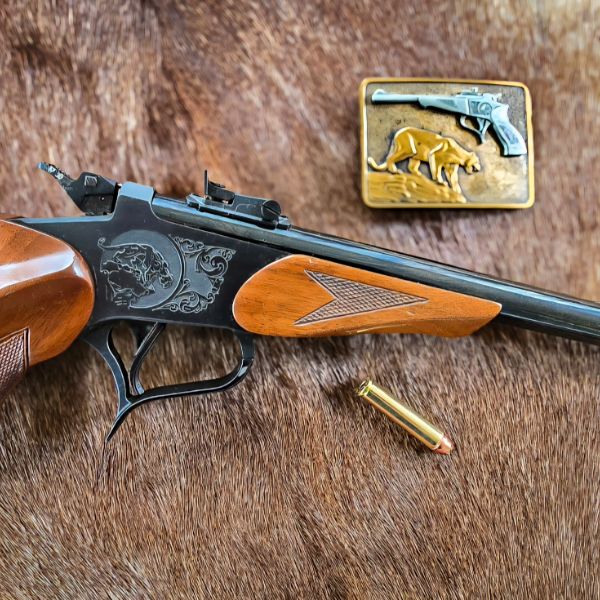 Stainless lever-action rifle with figured walnut stock leaning against a wooden chair