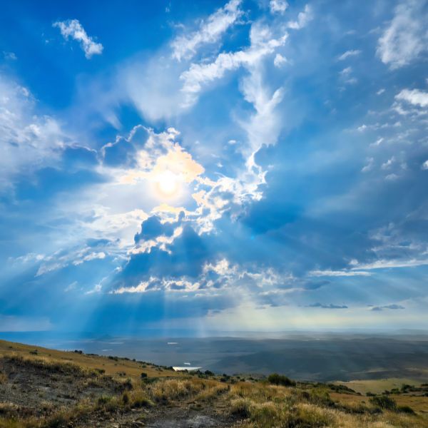 Sun breaking through cloud over open highveld grassland